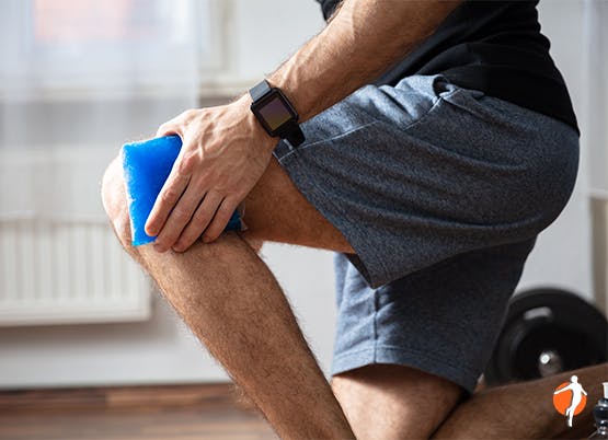 Man uses ice pack on knee pain Man uses ice pack on knee pain as part of RICE method