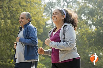 Older couple running through woods together