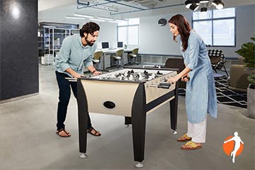 Man and woman playing table soccer