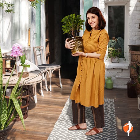 Woman happily holding her plant on her terrace