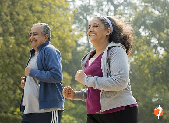 Elderly couple running trough the woods