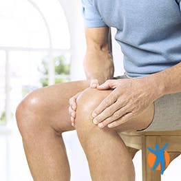 Person clutches knee with osteoarthritis pain