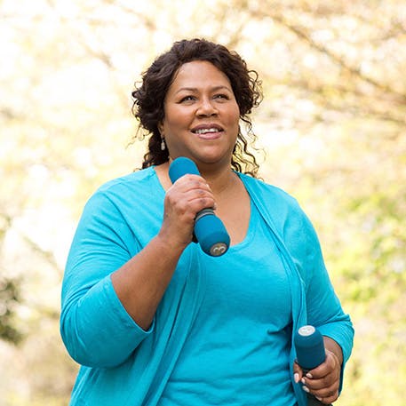 A woman power walking with small weights A woman power walking with small weights