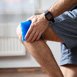 Man holds ice pack on knee Man holds ice pack on knee