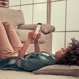 Woman laying on the floor with her feet on the sofa