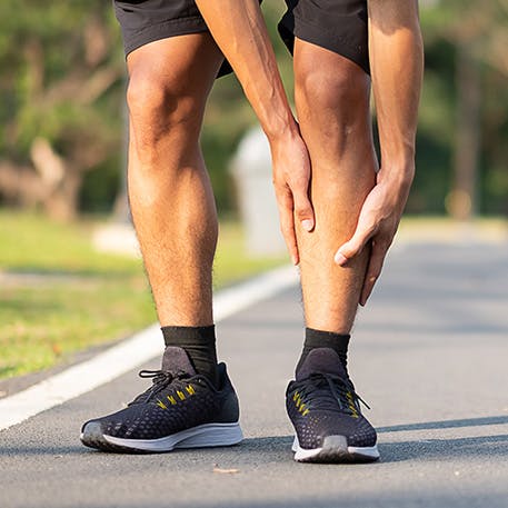 Man holding his shin and calf