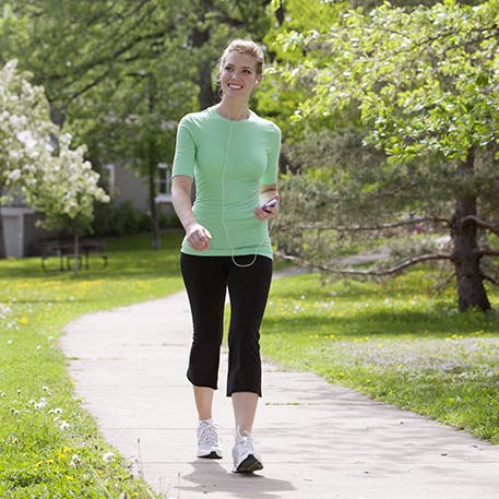 young woman takes a brisk walk in park