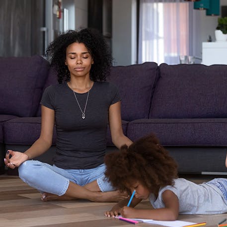 Woman meditating alongside child