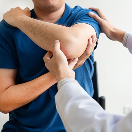 Man with a medical professional moving his shoulder Man with a medical professional moving his shoulder