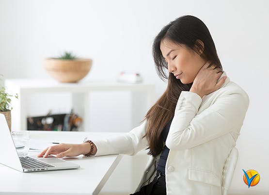 Mujer frente a un ordenador sujetando su cuello - Voltadol 