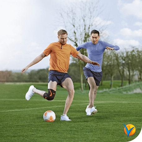 Hombre jugando al fútbol con rodillera - Voltadol 