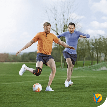 Hombre jugando al fútbol con rodillera - Voltadol