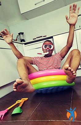 Un homme en maillot de bain dans sa cuisine au lieu d'être en vacances.