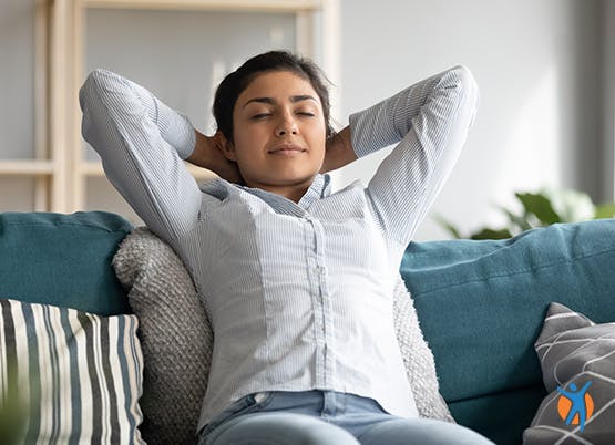 Femme se relaxant seule à la maison sur un canapé