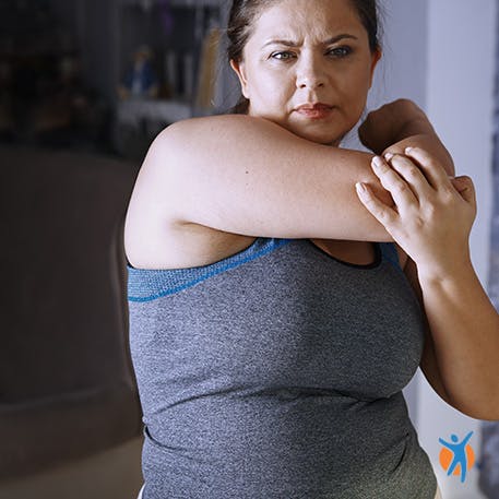A woman stretching her arm before exercise