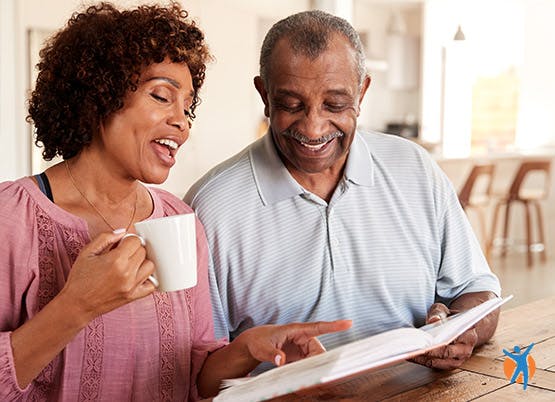 Casal a beber chá e a partilhar um livro.