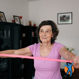 Mulher treina um exercício de extensão de ombros.
