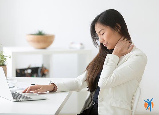 Mulher a trabalhar sentada e com evidência de dor no pescoço.