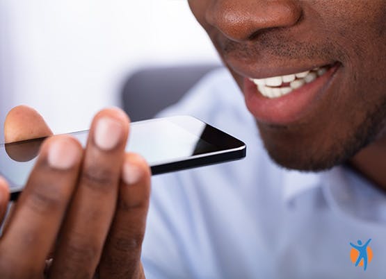 Close up of man using voice activation on his phone to search the Voltarol website