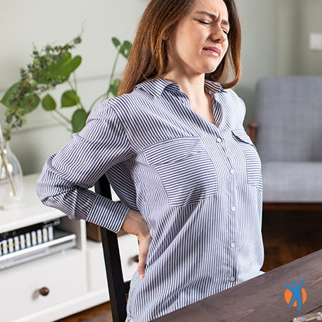 Muscle pain causes Man at computer holding his neck in pain - learn about the causes of muscle pain