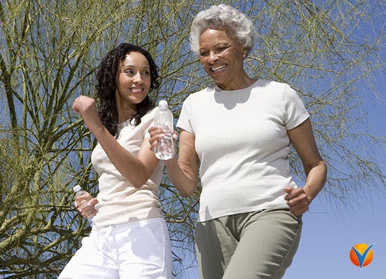 An elderly women and younger women walking outside