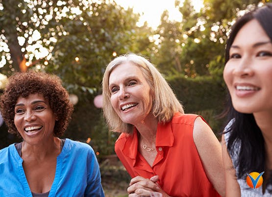three women smiling outside