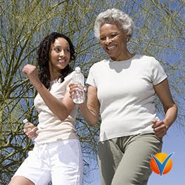 An elderly women and younger women walking outside
