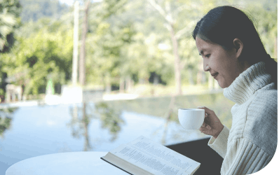 Woman having coffee while reading a book