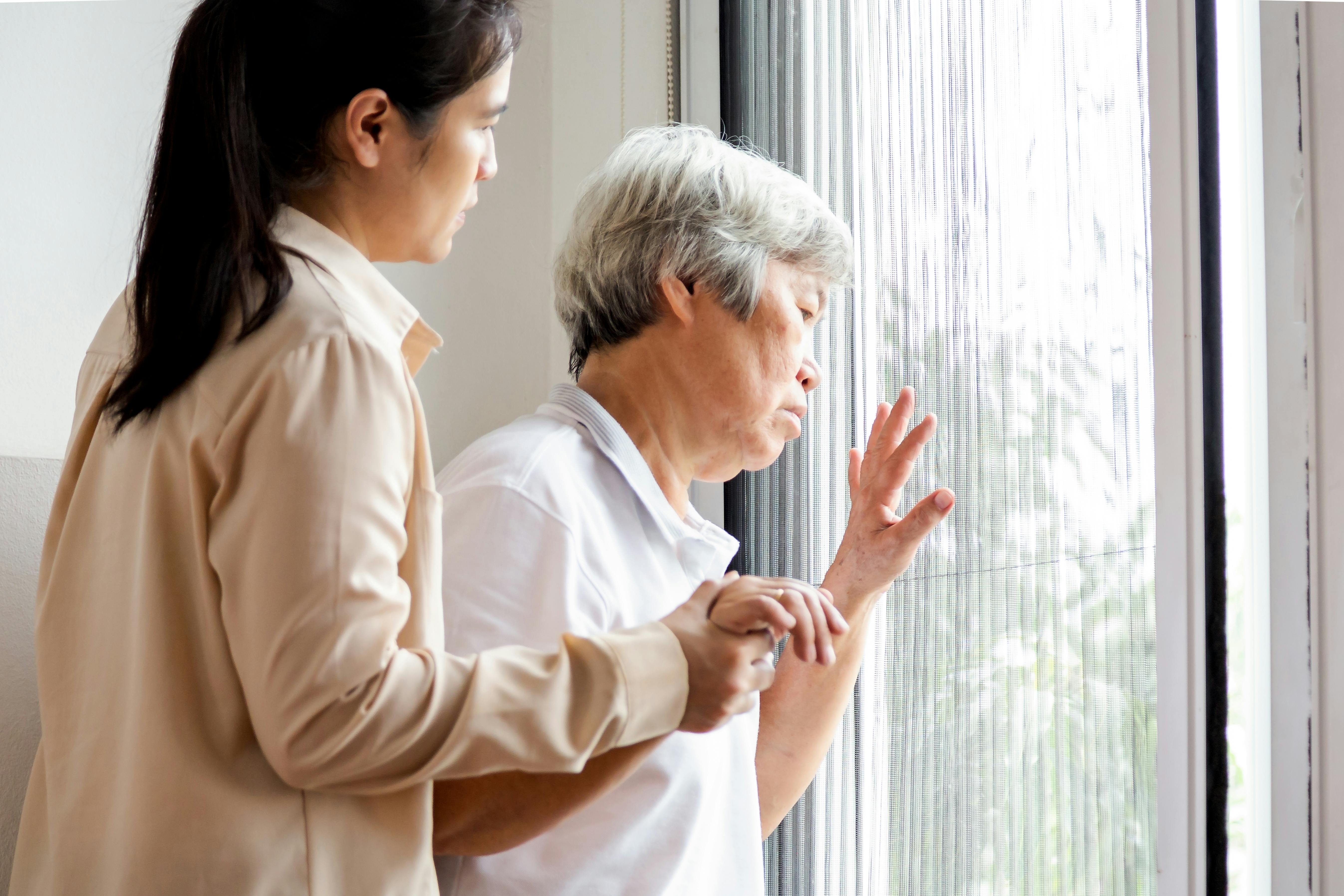 Woman and her caregiver look through a window