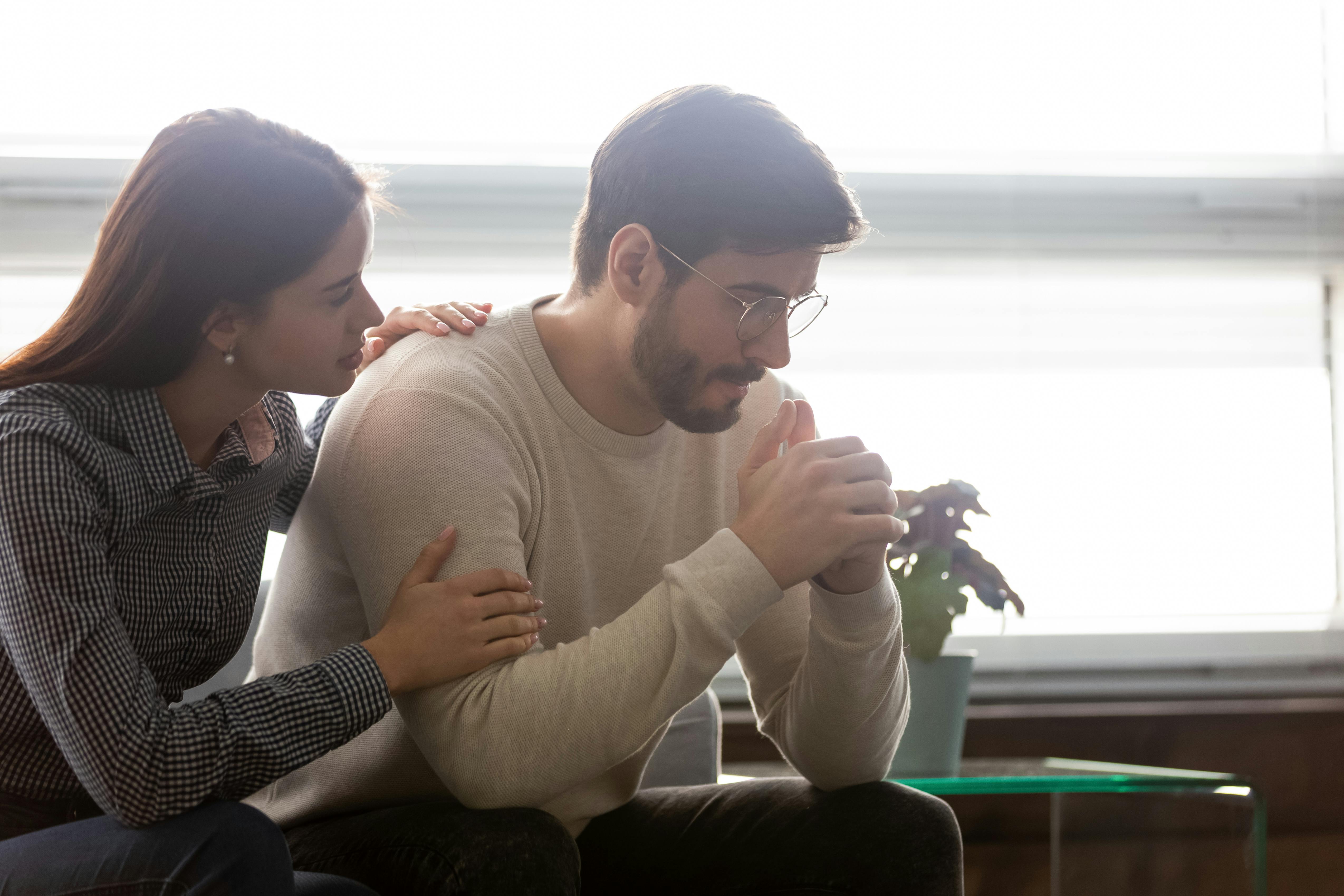 Tired man being comforted by woman