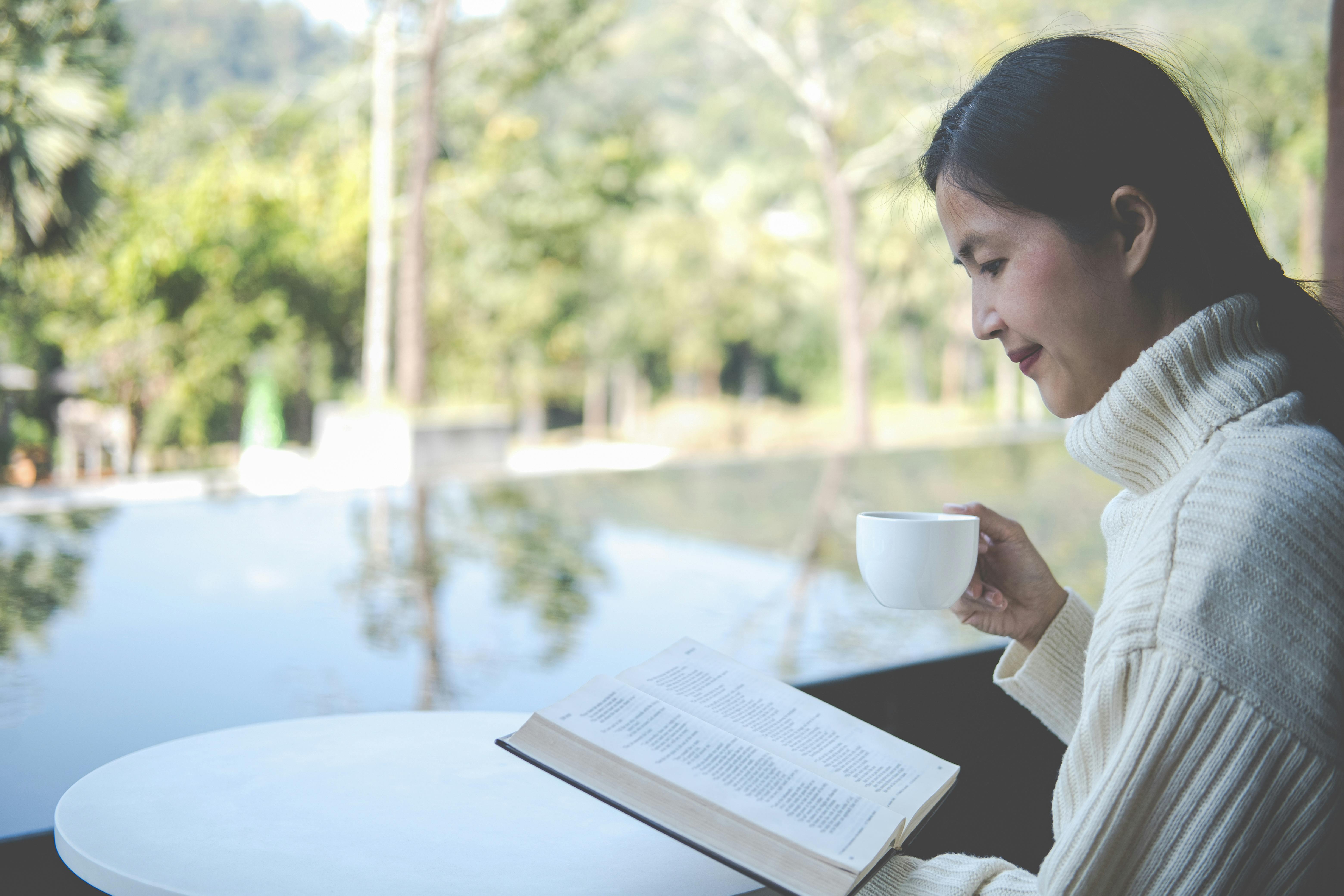 Woman reading a book with a cup of coffee