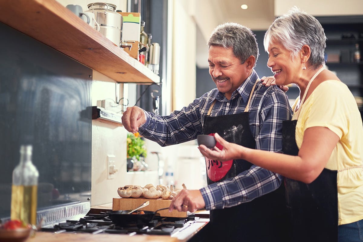 A male and female cooking together