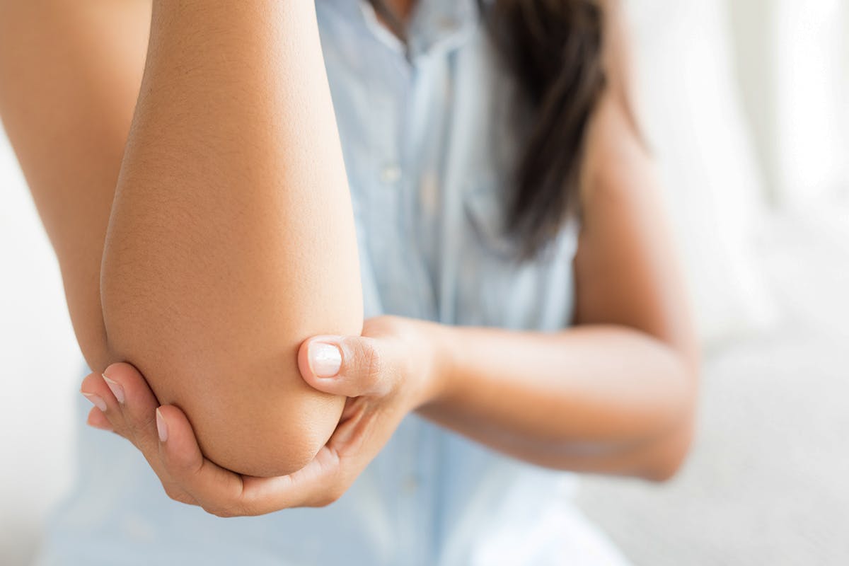 Woman holding elbow