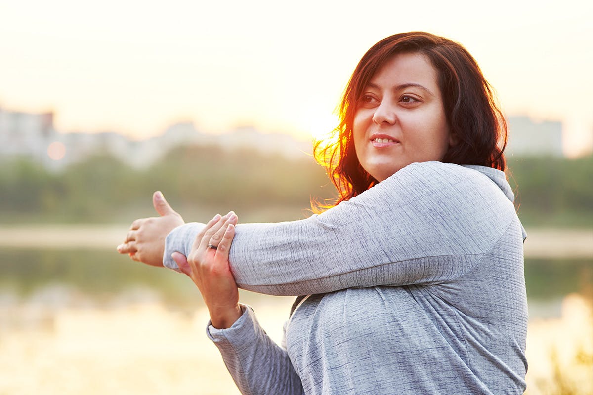 Woman stretching left arm across body