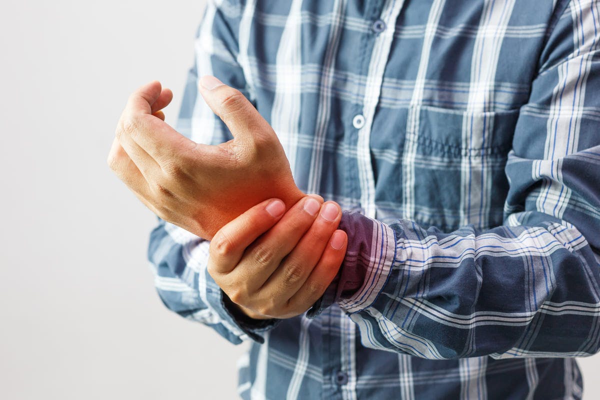 Man holding his wrists in pain from arthritis