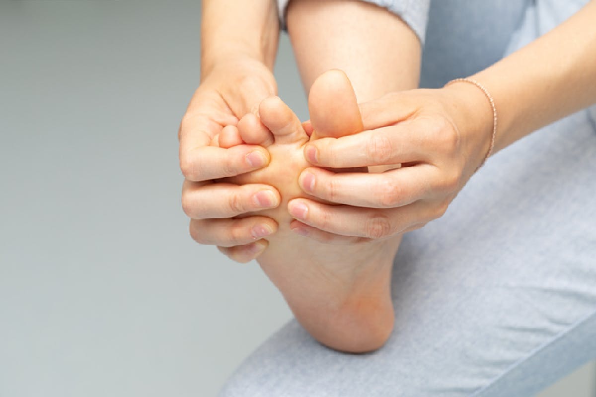 Close-up of a woman inspecting and rubbing her right foot
