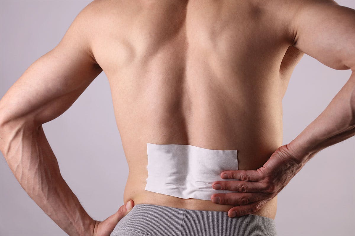 Man using lidocaine patch on back for arthritis pain