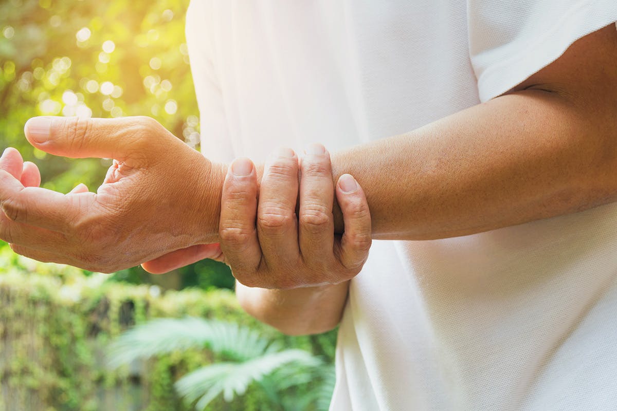 Person holding wrist in pain