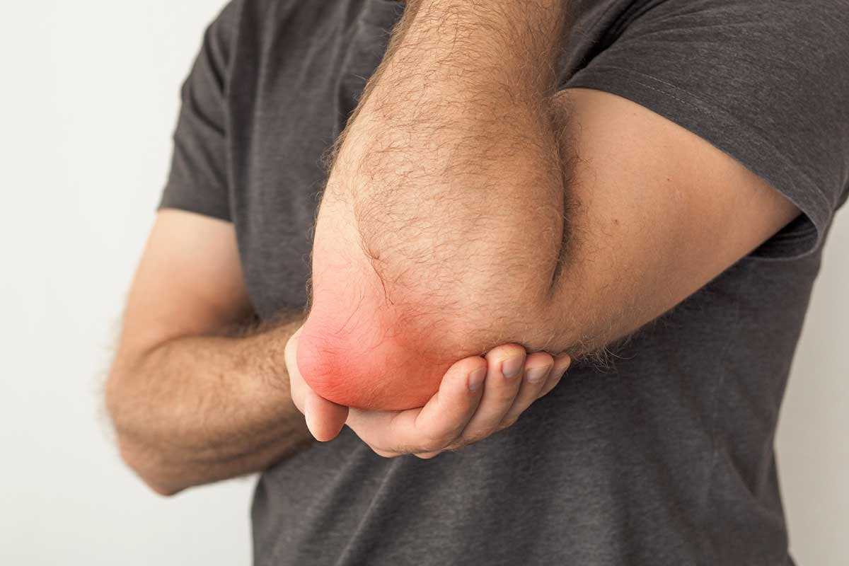 Man suffering from bursitis holds his elbow