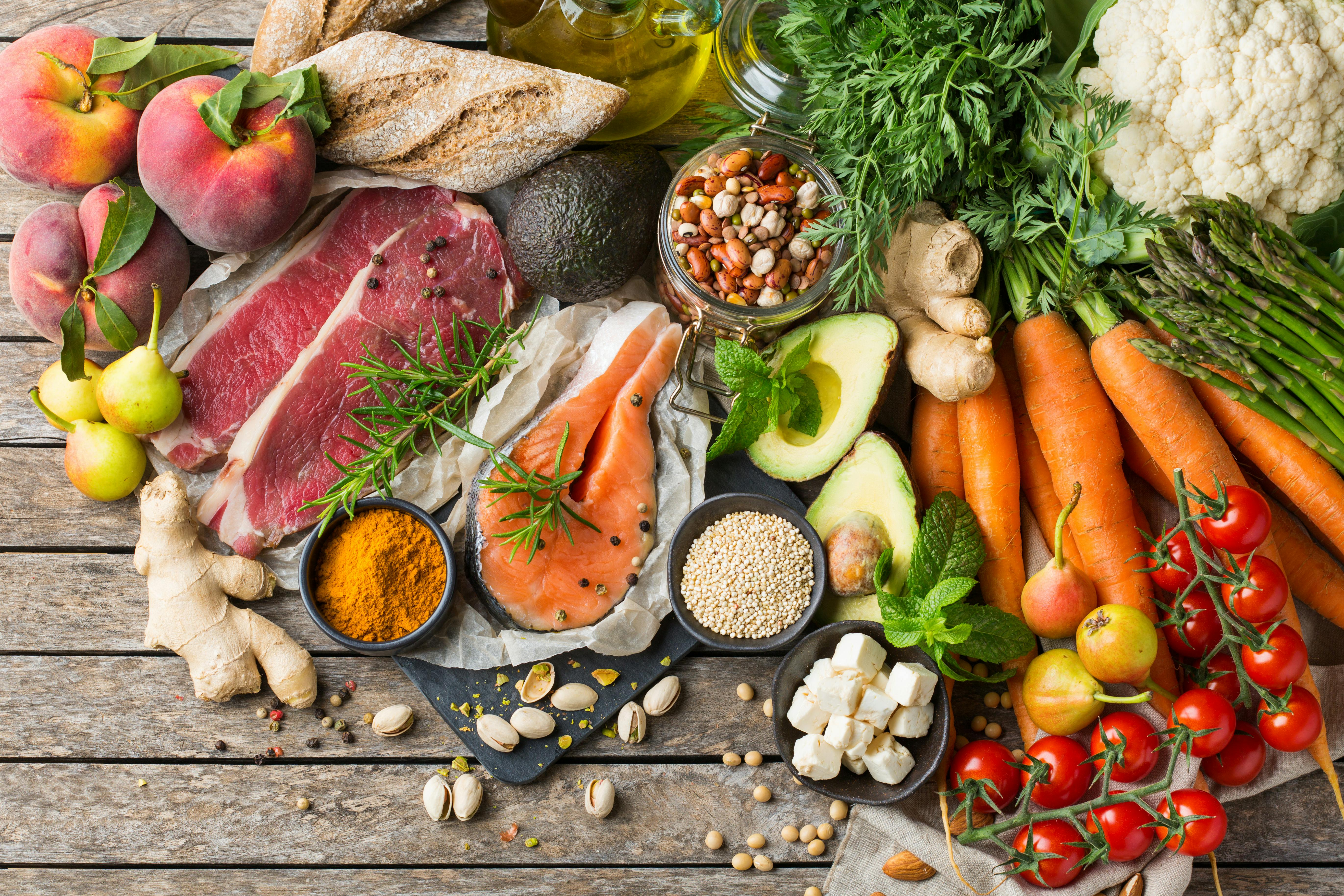 Table with a variety of fruits, vegetables, fish and nuts