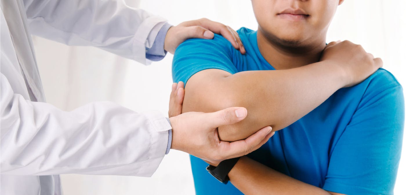 Patient with elbow pain receiving a diagnosis from a doctor