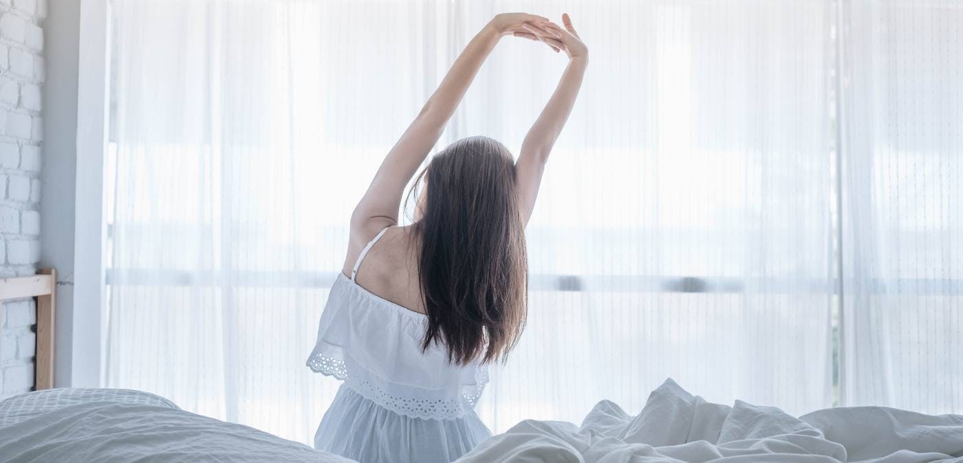 Young woman stretching after waking up