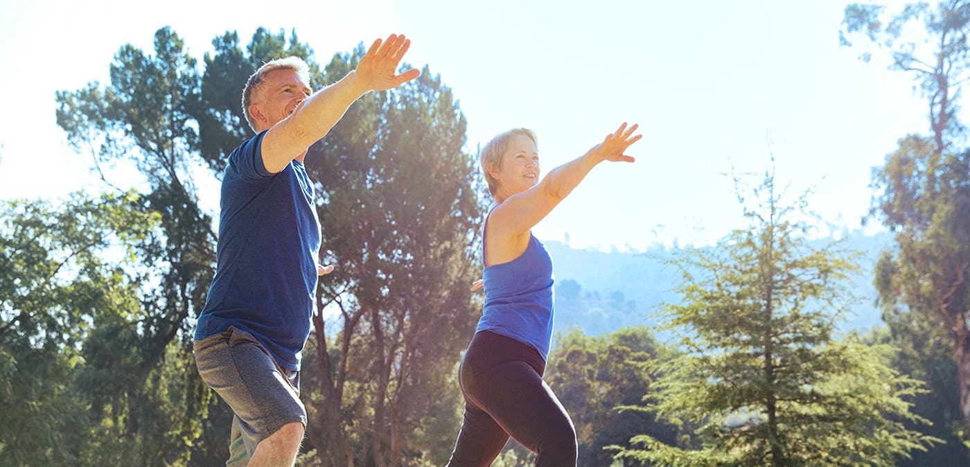 Man and woman doing yoga outdoors in nature