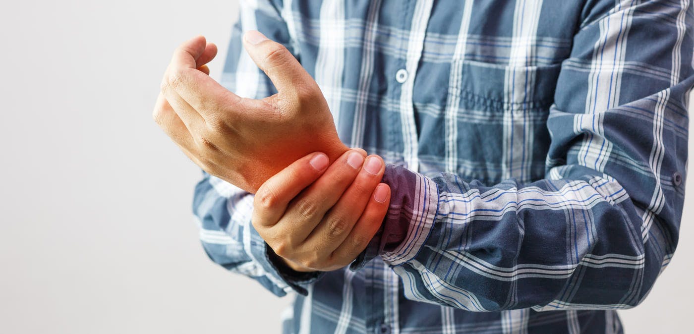 Man holding his wrists in pain from arthritis