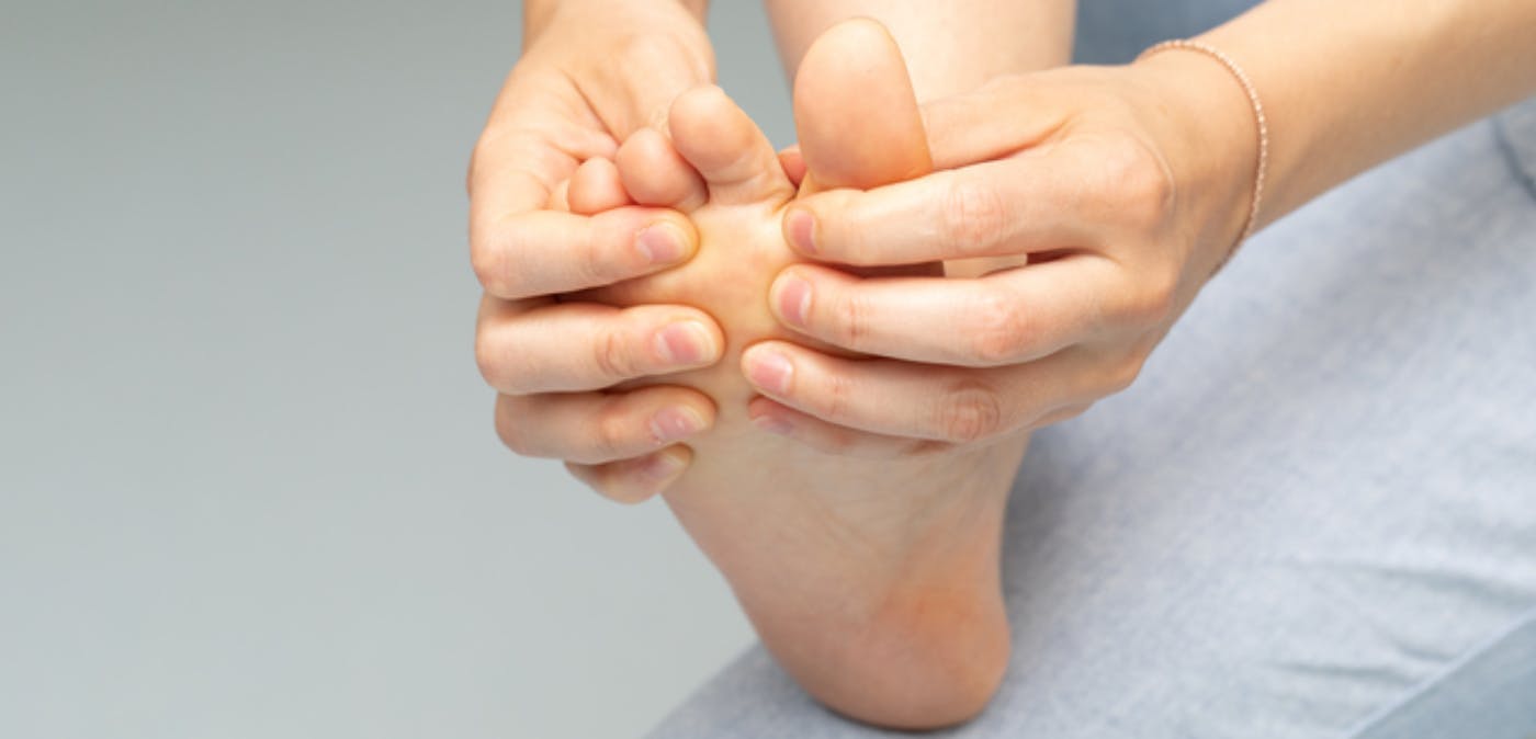 Close-up of a woman inspecting and rubbing her right foot