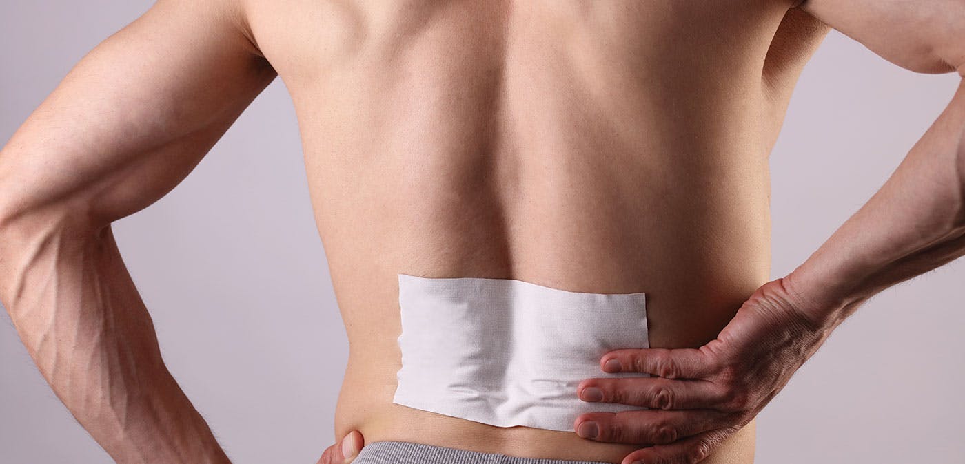 Man using lidocaine patch on back for arthritis pain
