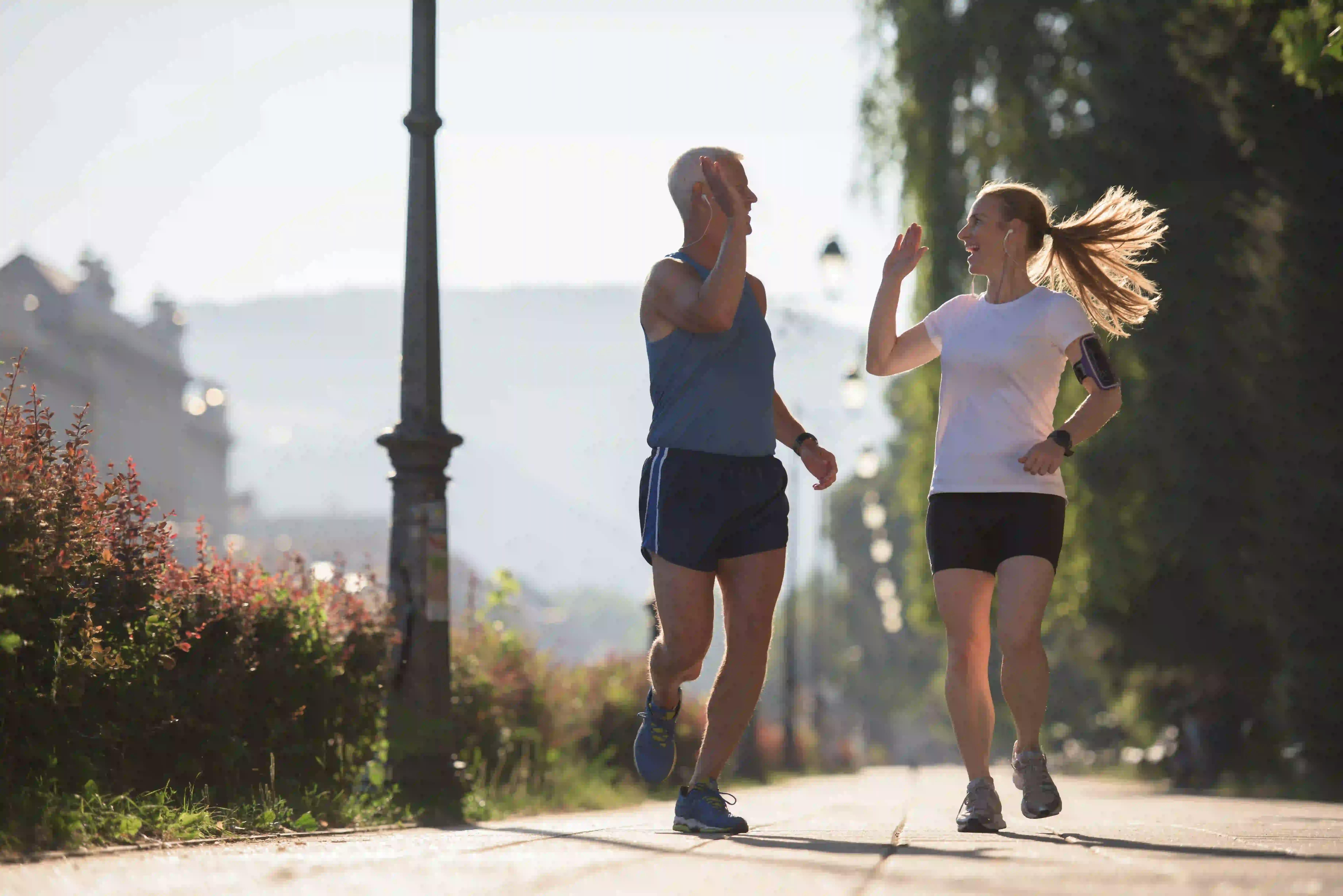 Man and woman high-fiving while jogging