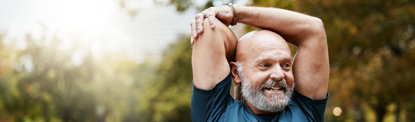 Man stretching arms in park