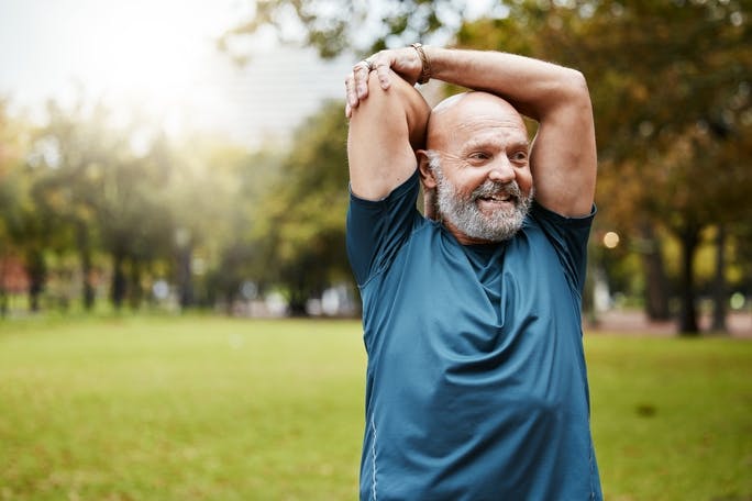 Man stretching arms in park