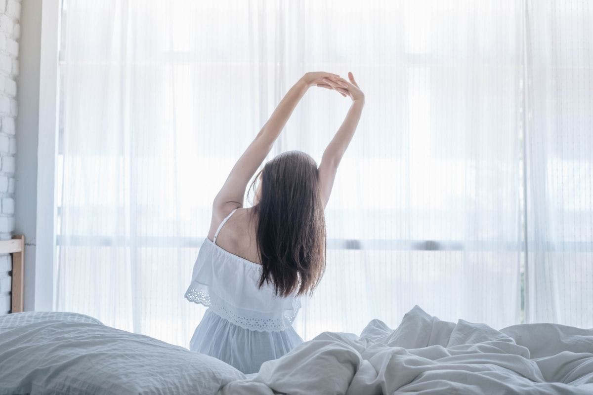 Young woman stretching after waking up